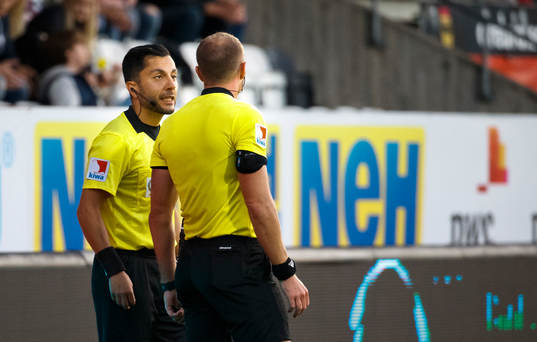 Domaren Patrik Eriksson pratar med linjemannen och 2-2