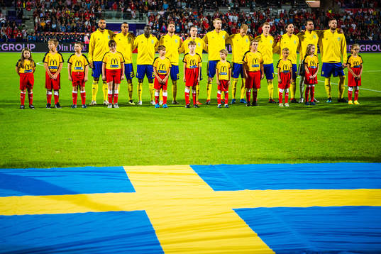 The Swedish flag is seen in front of the players of Sweden