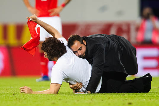 A pitch invader is wrestled by security