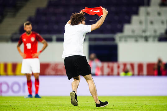 A pitch invader is wrestled by security
