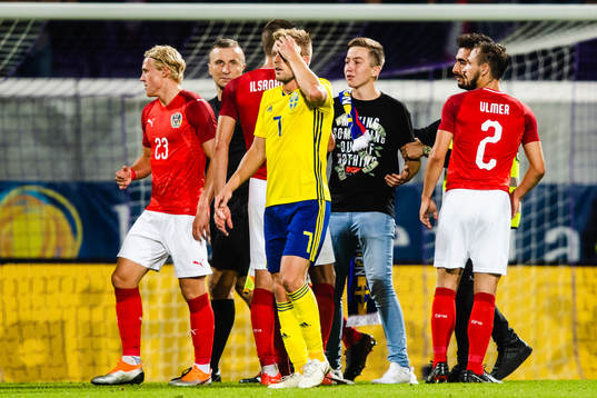 A pitch invader among Sebastian Larsson of Sweden and