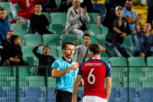 Referee Daniel Stefanski of Poland gives a red card to