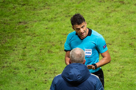 Referee Jesus Gil Manzano talks to head coach Janne