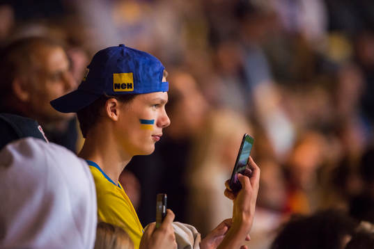 A swedish fan is taking a photo with his mobile phone