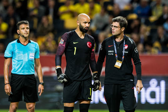 Goalkeeper Sinan Bolat of Turkey with a team staff