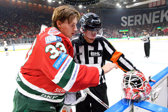 Frölundas målvakt Johan Mattsson reparerar sin mask