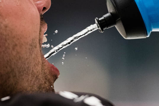 En spelare dricker vatten unnder uppvärmningen