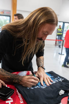Joacim Hans från Hammerfall signerar tröjor