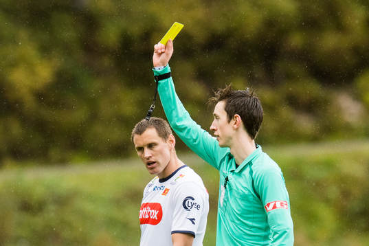 Tommy Høiland of Viking is shown a yellow card by Sivert