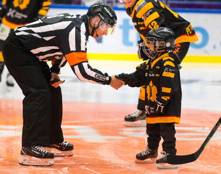 En knatte räcker över matchpucken till domare Sören