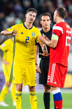 Mikael Lustig of Sweden with referee Luca Banti and Artem