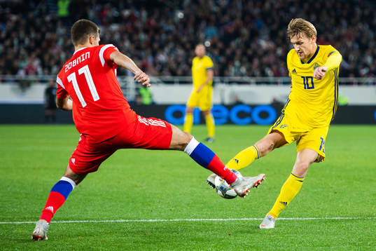 Roman Zobnin of Russia defends against Emil Forsberg of
