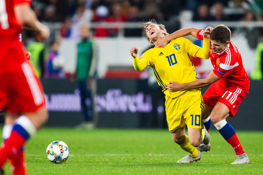 Emil Forsberg of Sweden is tackled by Roman Zobnin of Russia