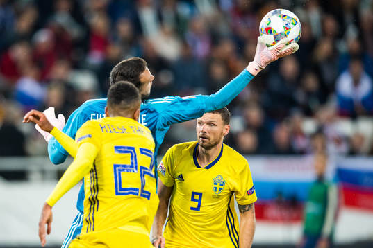 Isaac Kiese Thelin and Marcus Berg of Sweden challenges