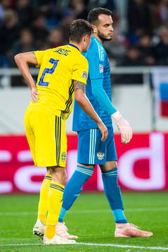Mikael Lustig of Sweden reaches for his back