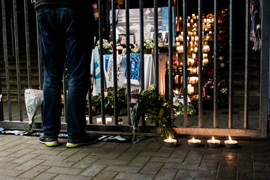 Besökare vid blommor, ljus och bilder