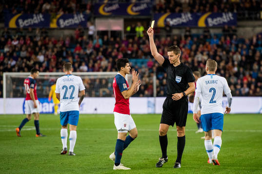 Tarik Elyounoussi of Norway is shown a yellow card by
