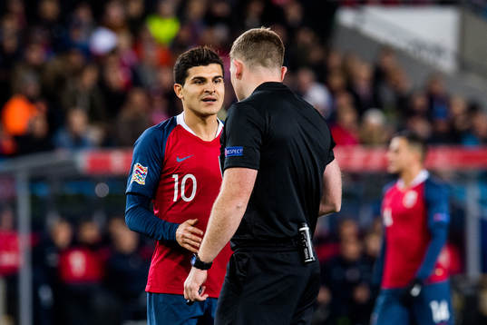 Tarik Elyounoussi of Norway and referee John Beaton of