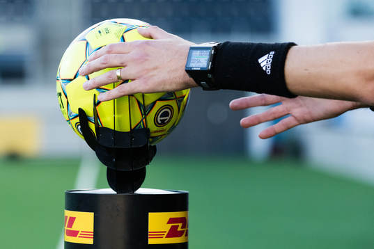 Domaren plockar upp matchbollen