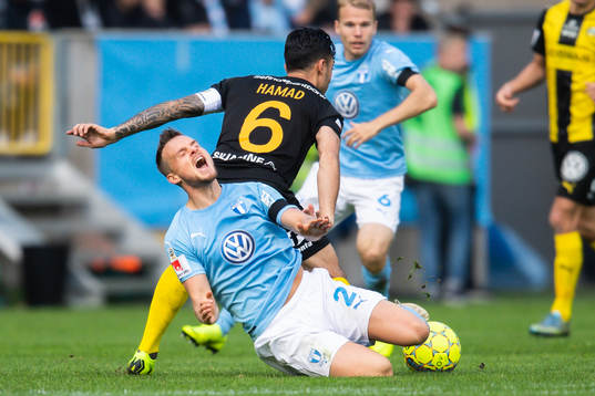 Malmö FFs Eric Larsson faller i en kamp med Hammarbys
