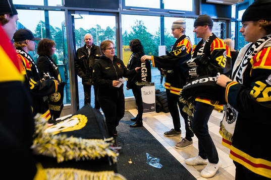 Publiken får halsdukar vid entrén innan ishockeymatchen i
