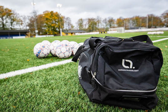 Väska och officiella matchbollar innan fotbollsmatchen i