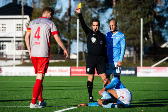 Kristian Jahr of Strømmen receives a yellow card from