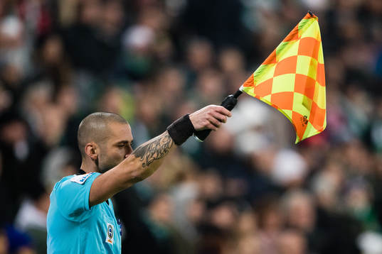 En linjedomare vinkar för offside