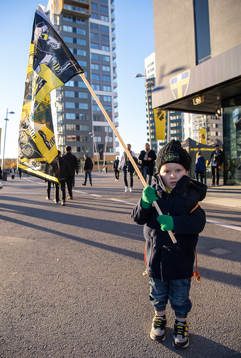 En ung AIK-supporter håller upp en flagga