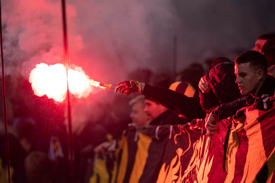 En AIK supporter bränner en bengal