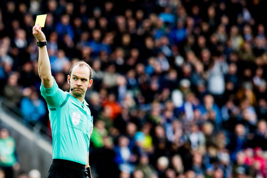 Christian Moen, referee, shows a yellow card