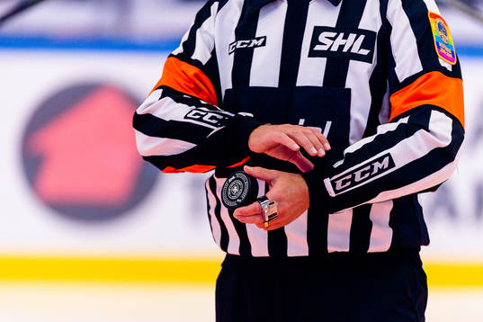 En domare håller en matchpuck
