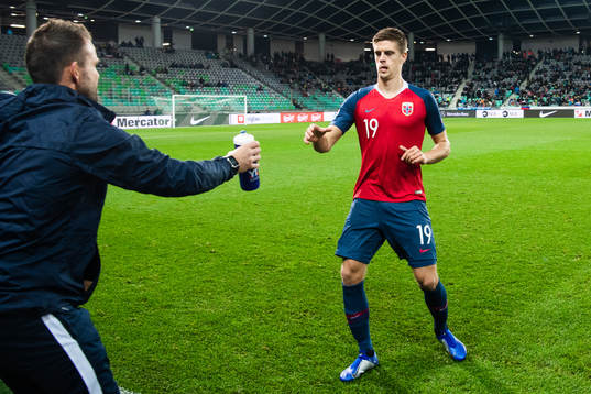 Markus Henriksen of Norway is handled a bottle