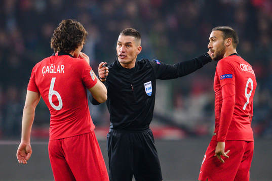 Caglar Söyuncu of Turkey in a discussion with referee