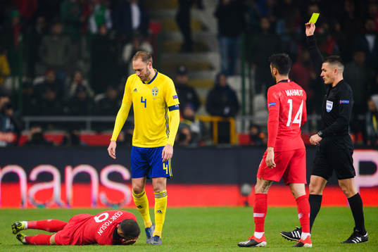 Andreas Granqvist of Sweden receives a yellow card from