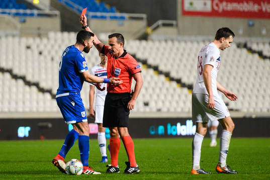 Valentinos Sielis of Cyprus receives a red card from