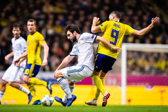 Giorgi Dzhikiya of Russia and Marcus Berg of Sweden