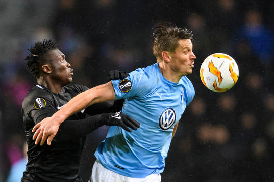 Joseph Aidoo of Genk in action with Markus Rosenberg of
