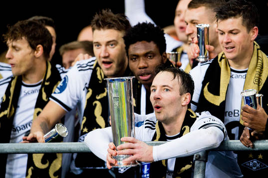 Mike Jensen of Rosenborg lifts the trophy in front of