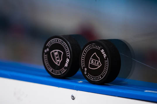 Två puckar med Djurgårdens emblem på