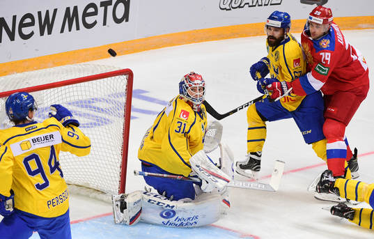 Sweden's goalie Lars Johansson, centre, watches a puck