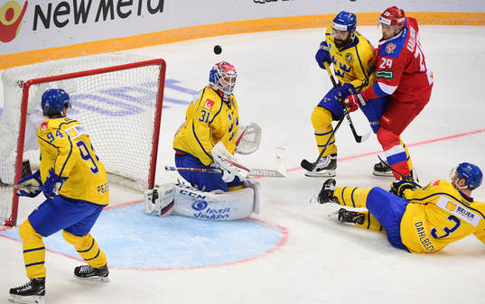 Sweden's goalie Lars Johansson, centre, watches a puck