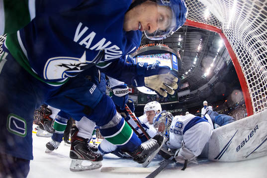 Bo Horvat of Vancouver Canucks and Mikhail Sergachev and
