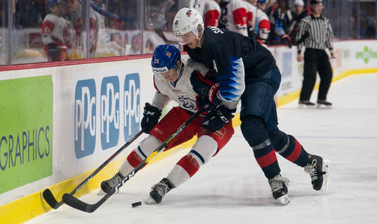 Dylan Samberg #4 of the United States tries to bodycheck