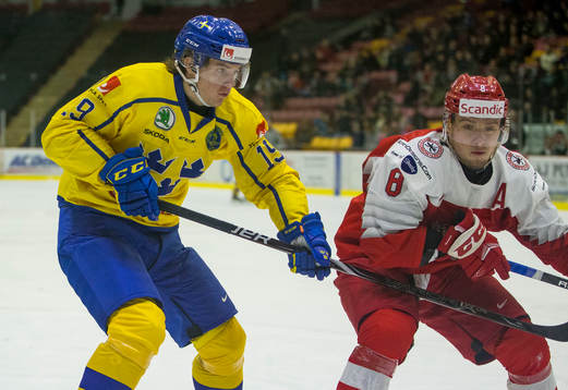 Sweden forward Filip Hållander (19) checks Denmark