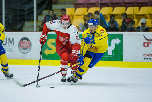 Sweden forward Filip Sveningsson (17)  checks Denmark