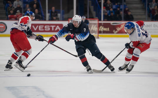 Quinn Hughes #7 of the United States gets past Jan Hladonik