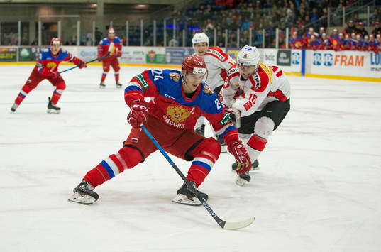 Switzerland defenceman Nico Gross (16)  checks Russia