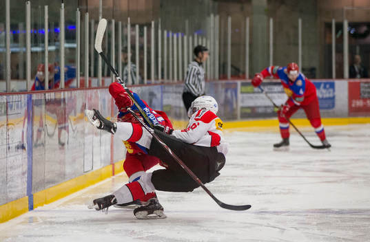 Switzerland defenceman Nico Gross (16)  checks Russia