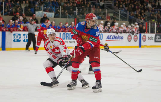 Switzerland defenceman Nico Gross (16)  battles with Russia